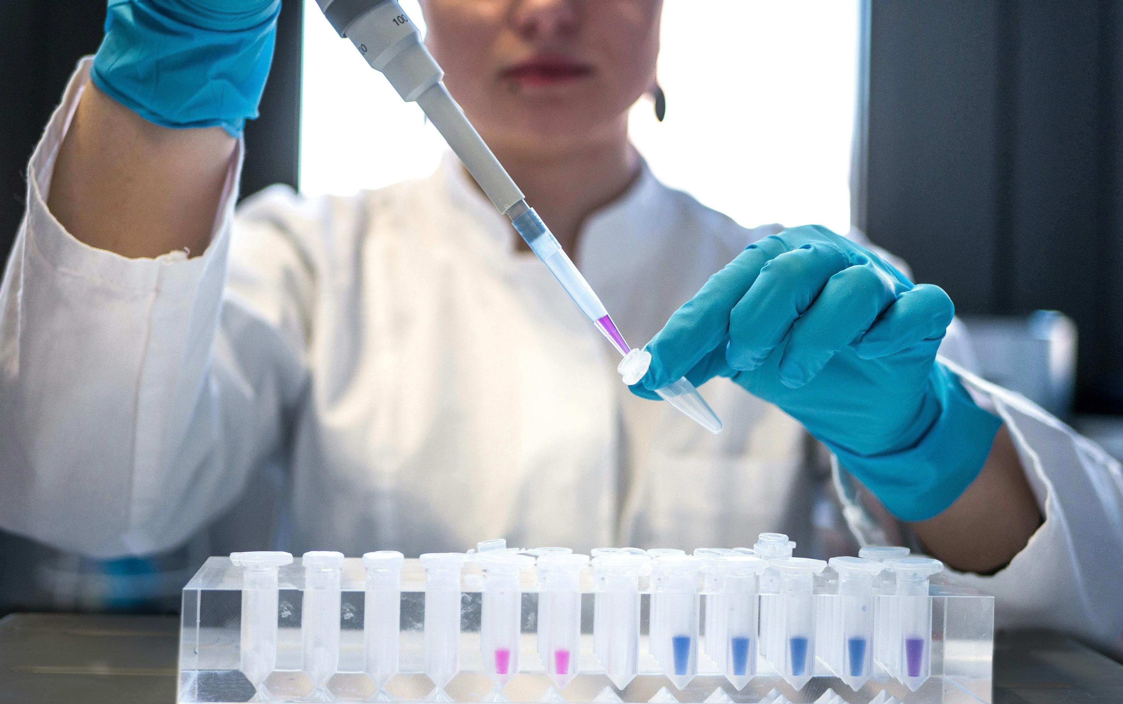 Nhà khoa học dùng pipet với ống nghiệm trong phòng xét nghiệm