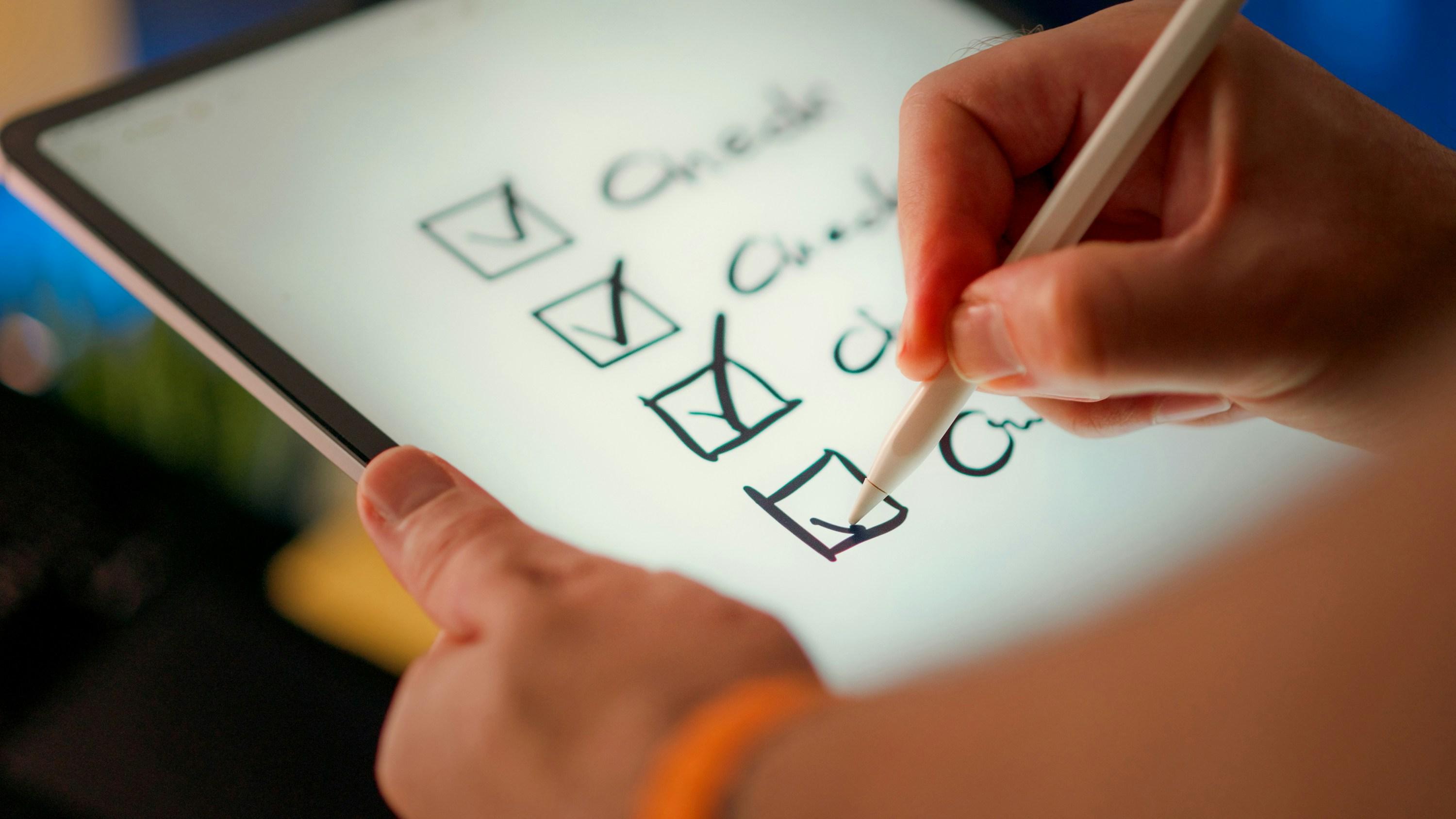 Bàn tay đánh dấu các mục trên danh sách checklist tuân thủ